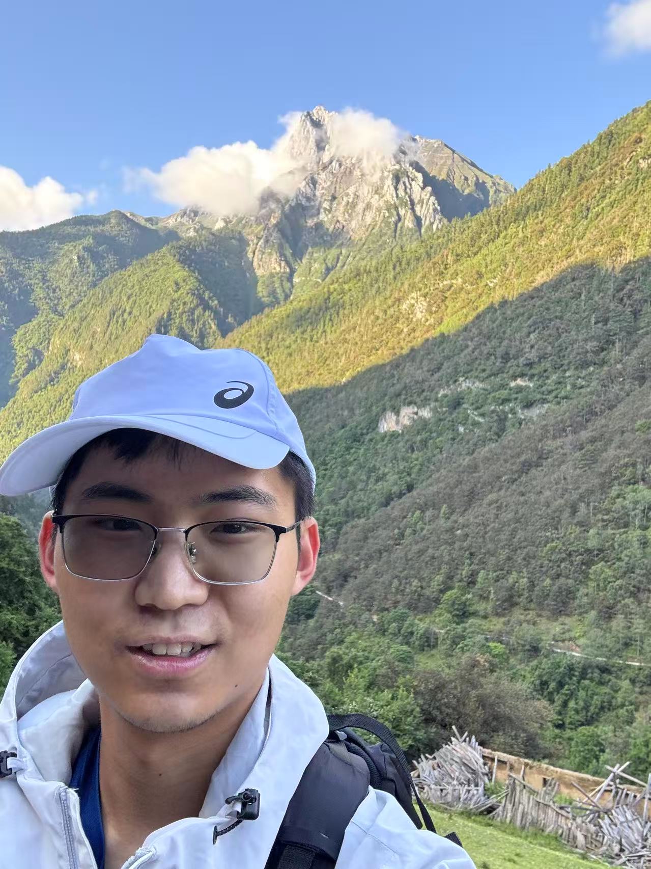 A hiking selfie with a sunlit mountain in the background
